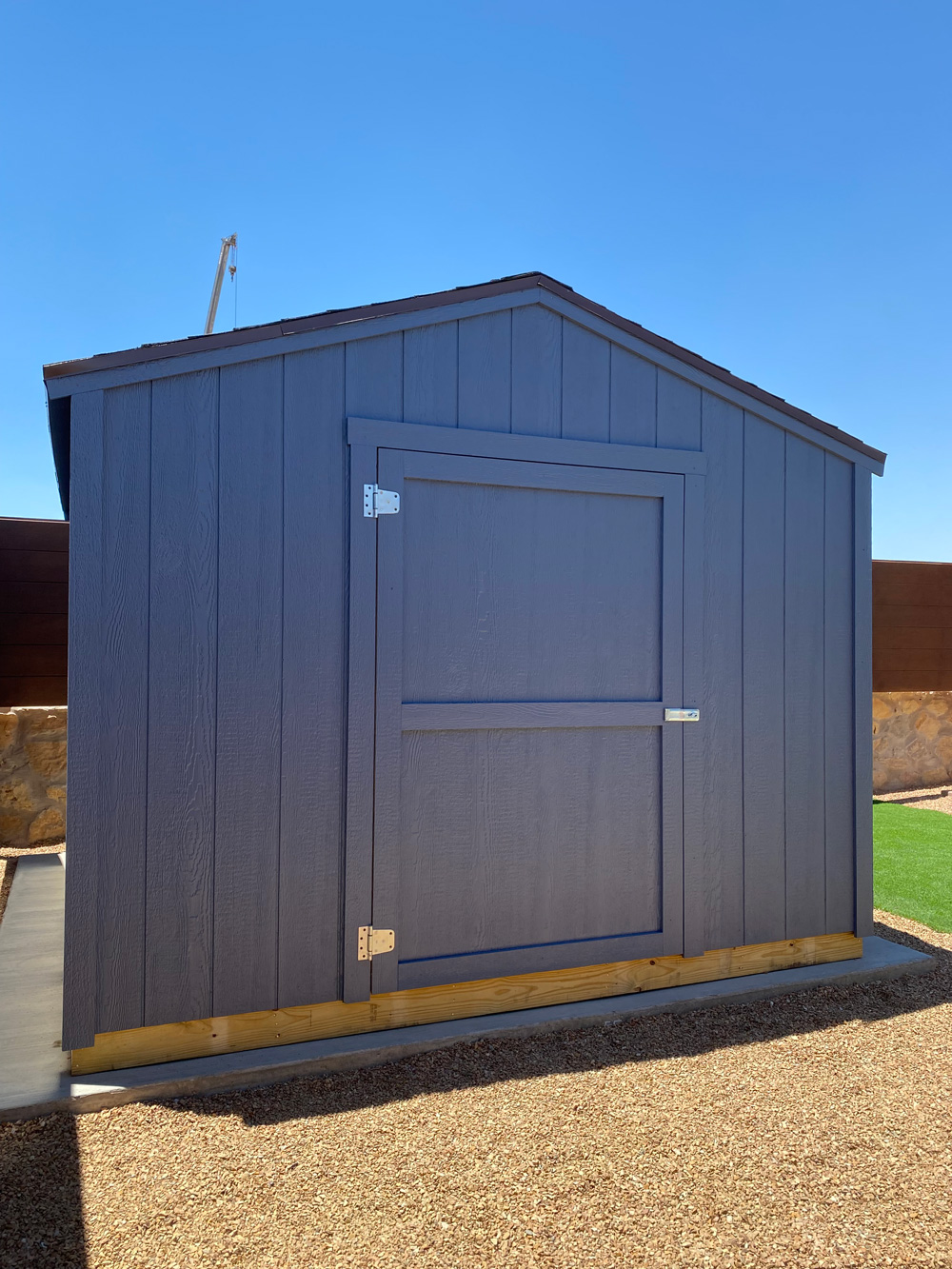 A grey outdoor storage shed in a backyard in El Paso.